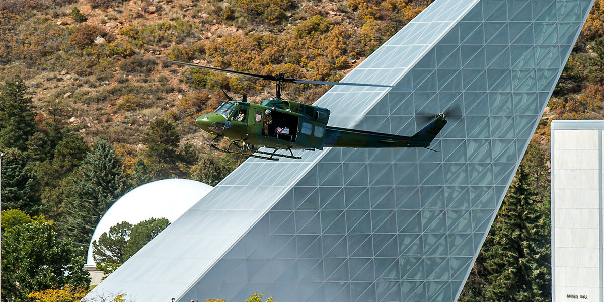 A military helicopter flies past Polaris Hall at the Academy.