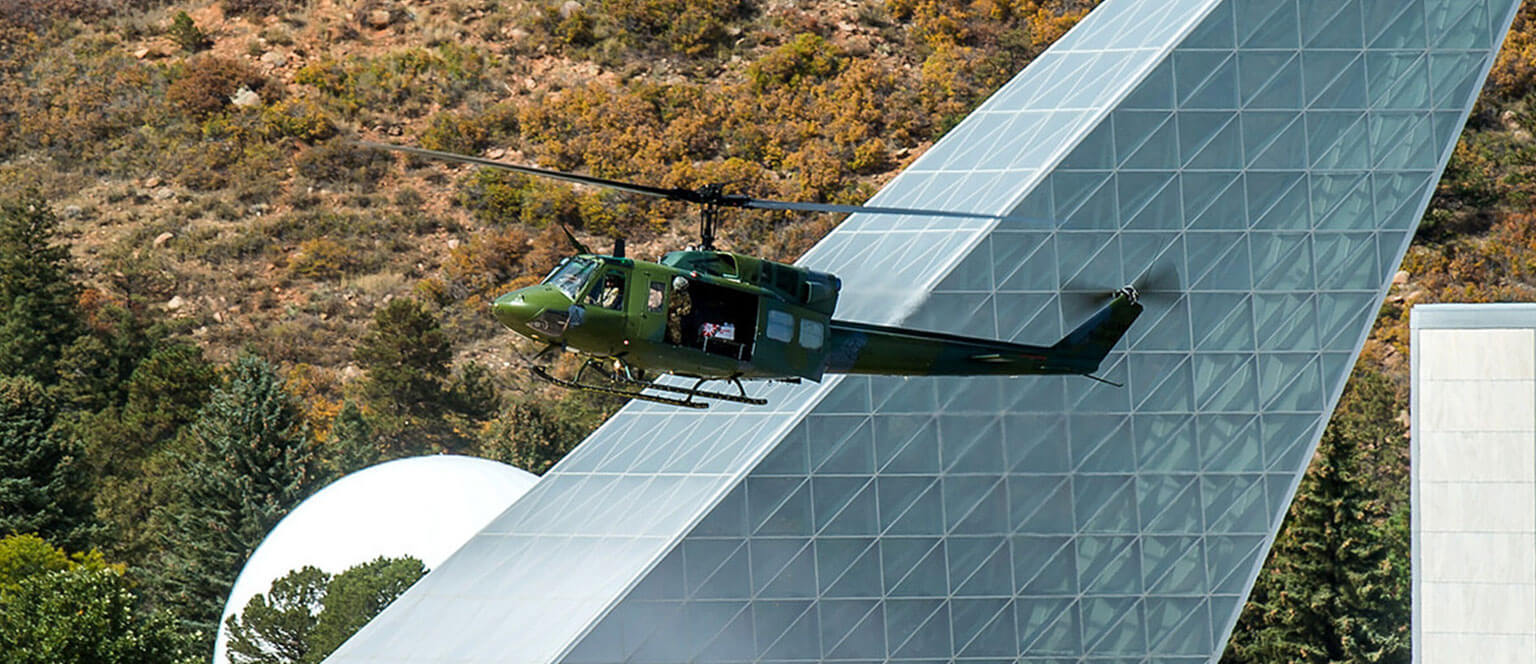 A military helicopter flies past Polaris Hall at the Academy.