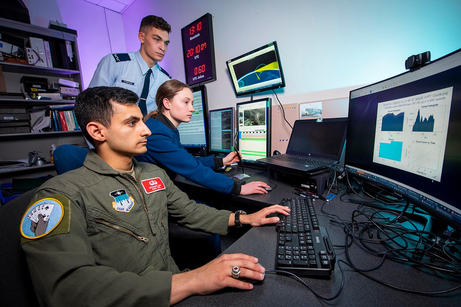 Cadets Liam Champagne, Kaylee King, and Rayomand Bam conduct data analysis in the SPARC’s data operations center on March 1, 2022