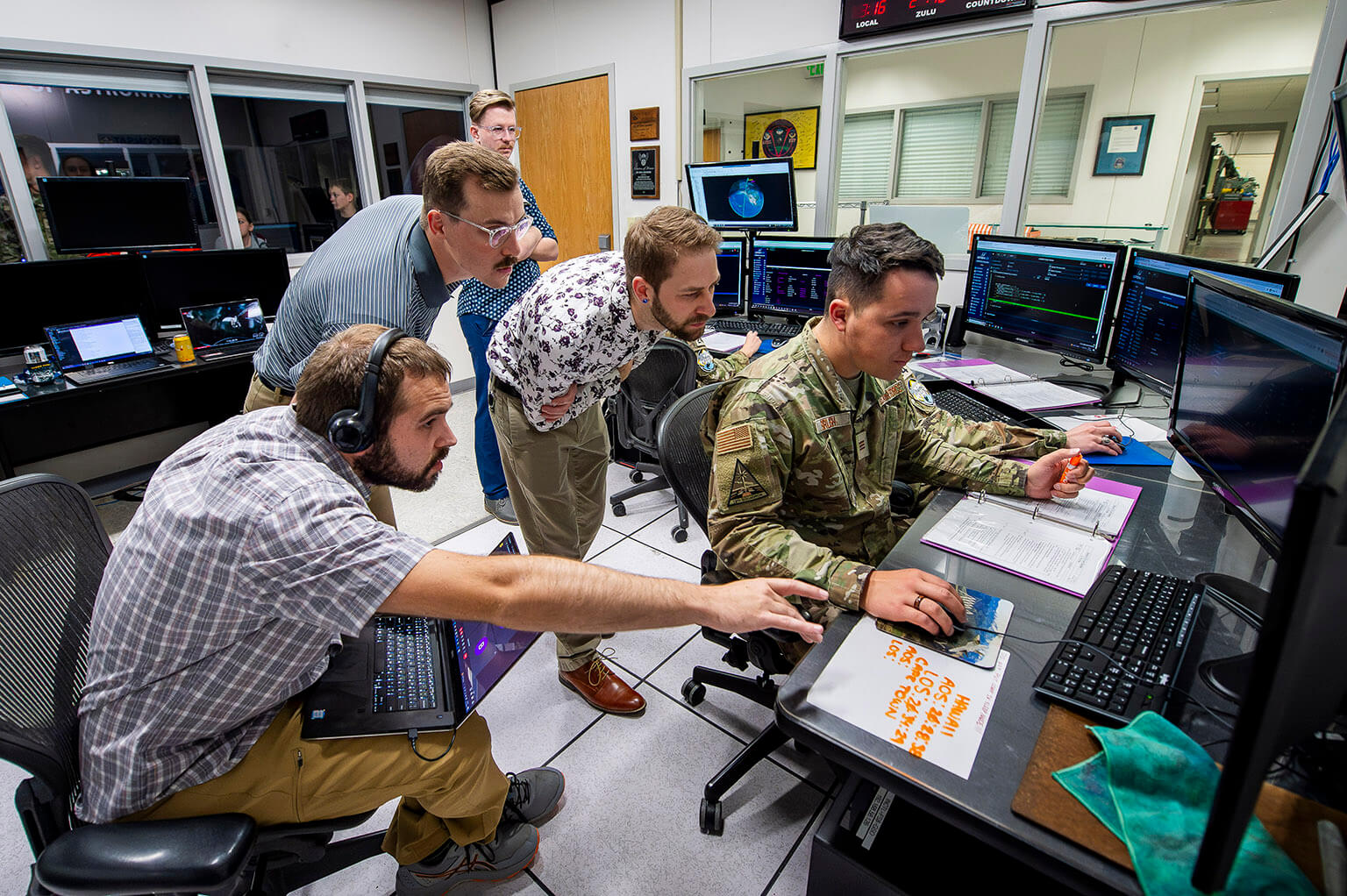 Engineers (from left) Braden Virdell, Seth Hart, Zane Sauer and Jack Hallowell watch U.S. Air Force Academy Cadet 1st Class Parker Brush operate FalconSAT-X 