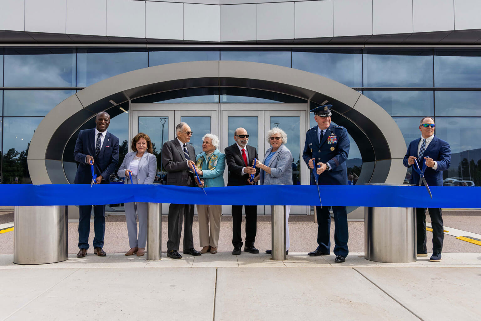 Colorado Springs Mayor Yemi Mobolade, from left, Colorado Lt. Governor Dianne Primavera, Lt. Gen. (Ret.) Bradley Hosmer, Zita Hosmer, Jerry Bruni, Pam Bruni, Academy Superintendent Lt. Gen. Tony Bauernfeind, and Sam Schnepf cut the ribbon during the Hosmer Visitor Center ribbon cutting, May 15, 2026, at the U.S. Air Force Academy. The ceremony marked the official opening of the 34,000-square-foot center designed to showcase the cadet experience and Academy heritage. (U.S. Air Force Photo by Trevor Cokley)