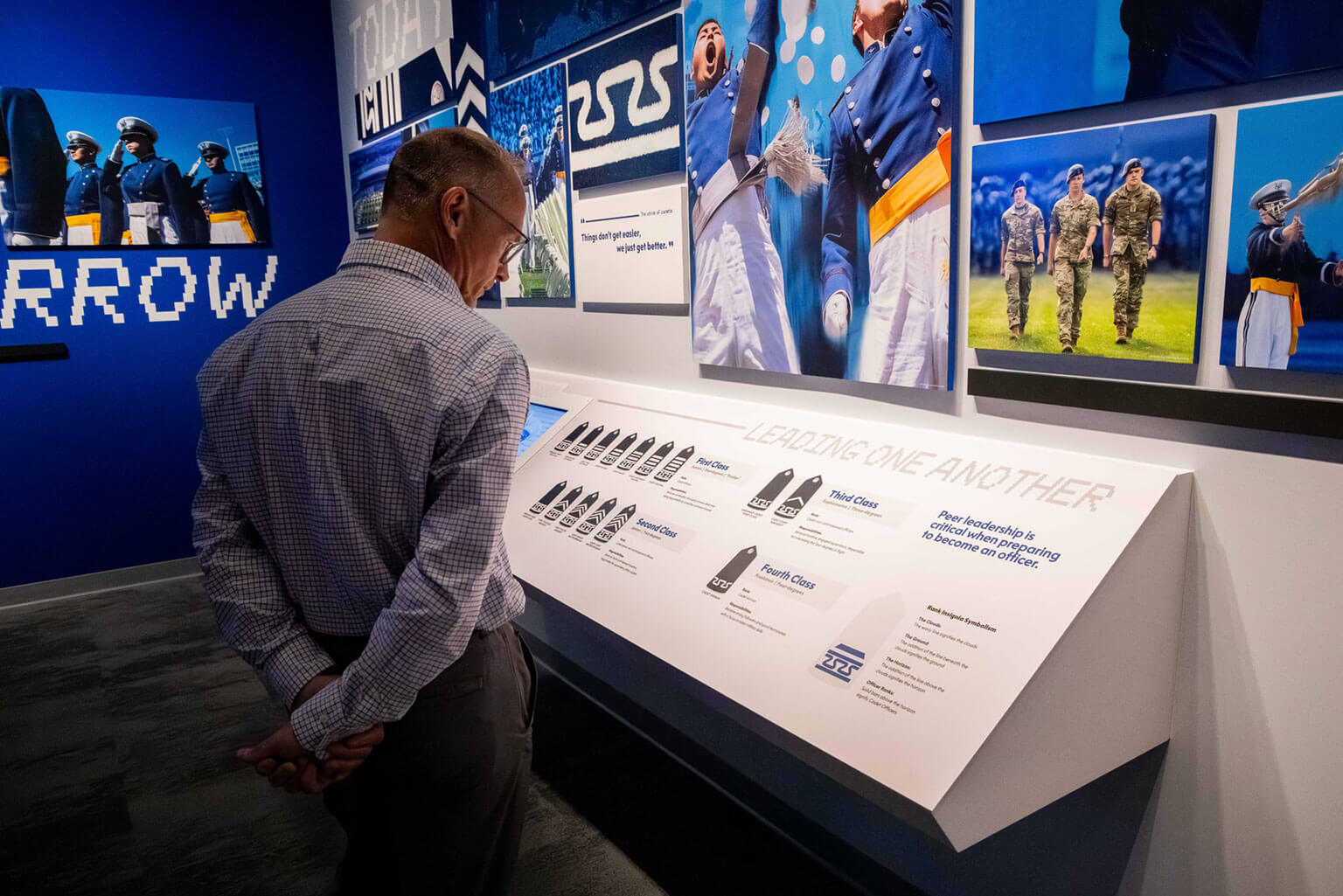 An attendee studies cadet rank at the U.S. Air Force Academy’s Hosmer Visitor Center following the Hosmer Visitor Center ribbon cutting May 15, 2026. Interactive exhibits throughout the center introduce visitors to cadet life, such as rank structure, training and Academy traditions. (U.S. Air Force Photo by Trevor Cokley)