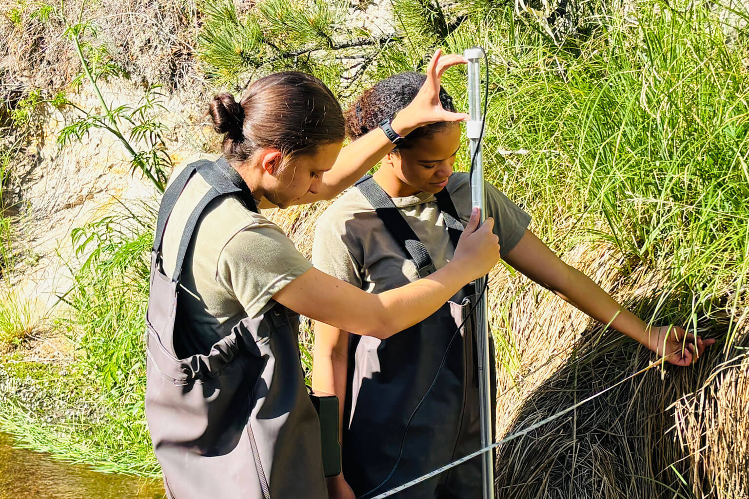 Cadet 2nd Class Kimberly Cahoon (left) and Cadet 2nd Class Soeul Cody (right) conduct stream monitoring along Monument Creek at the U.S. Air Force Academy, June 16, 2026. As part of water resources field operations, cadets collect field data and develop the engineering judgment needed to assess water resources, infrastructure performance and environmental conditions. (Courtesy photo by Lt. Col. Kathleen Smits)