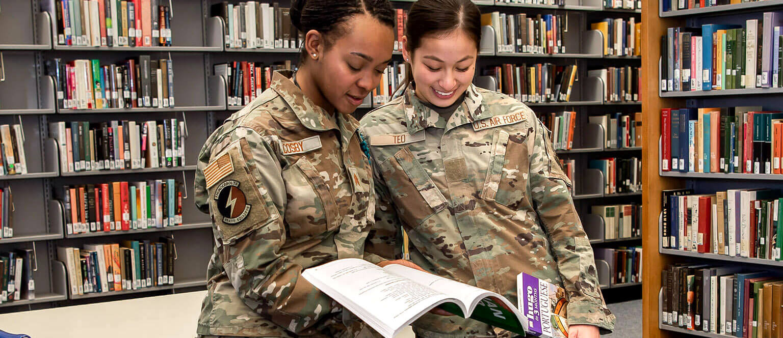 Cadets reviewing text book in McDermott Library.
