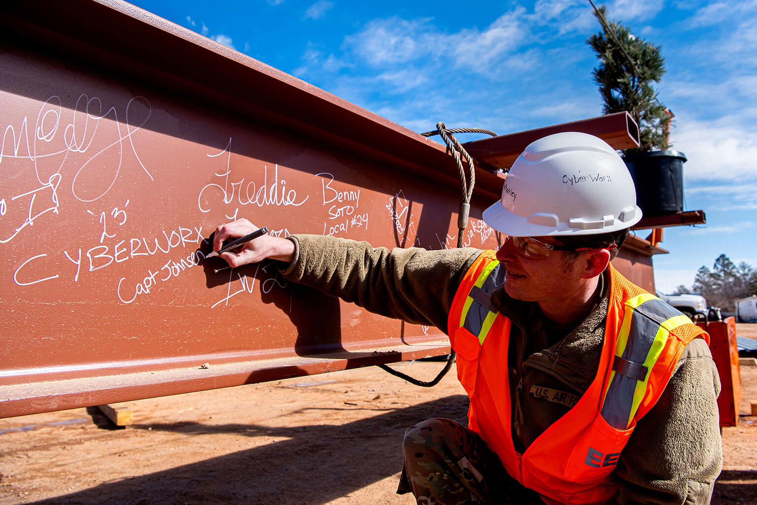 Capt. Nathan Johnsen, Air Force Academy CyberWorx program manager signing beam