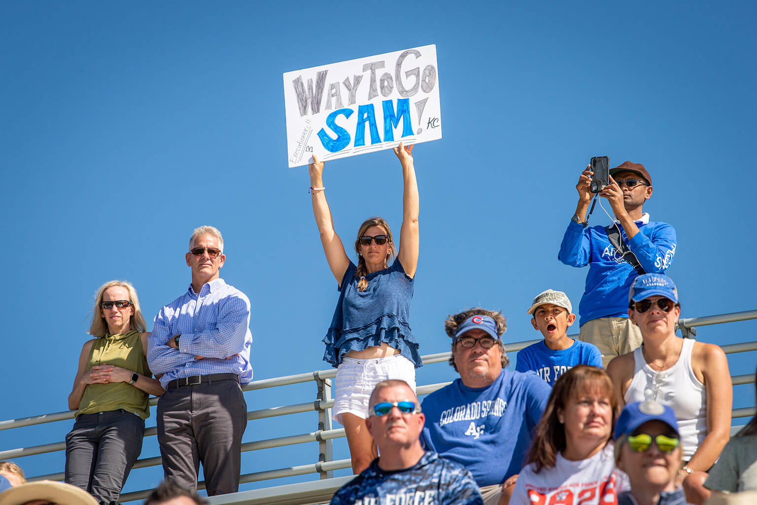 Parents in stands with sign