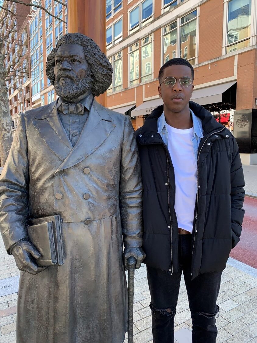 Masozera with a statue of Frederick Douglass