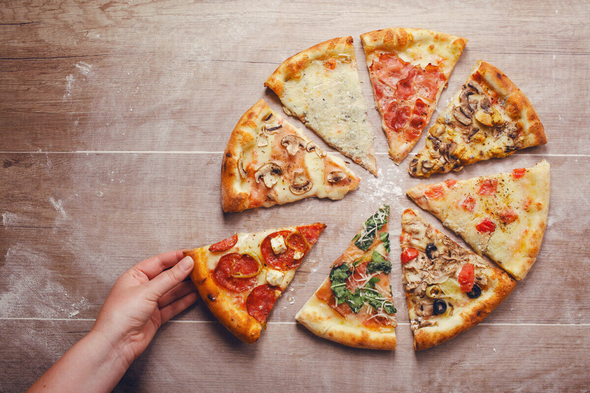 Hand grabbing piece of pizza