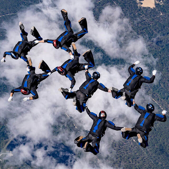 Eight competition team members in tight group formation