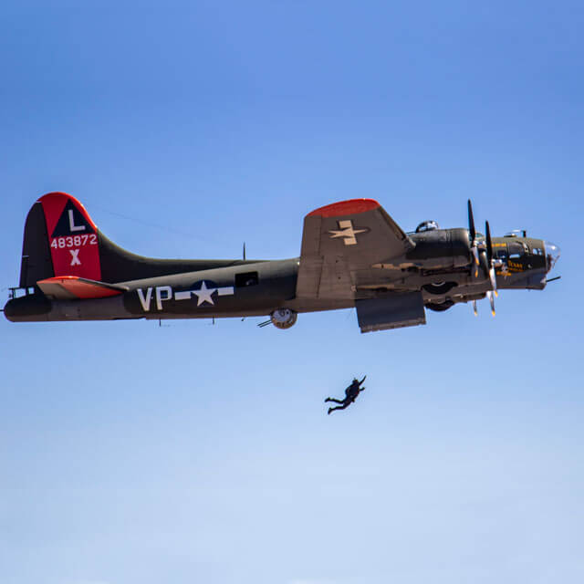 Wings of Blue member jumping out of B-17