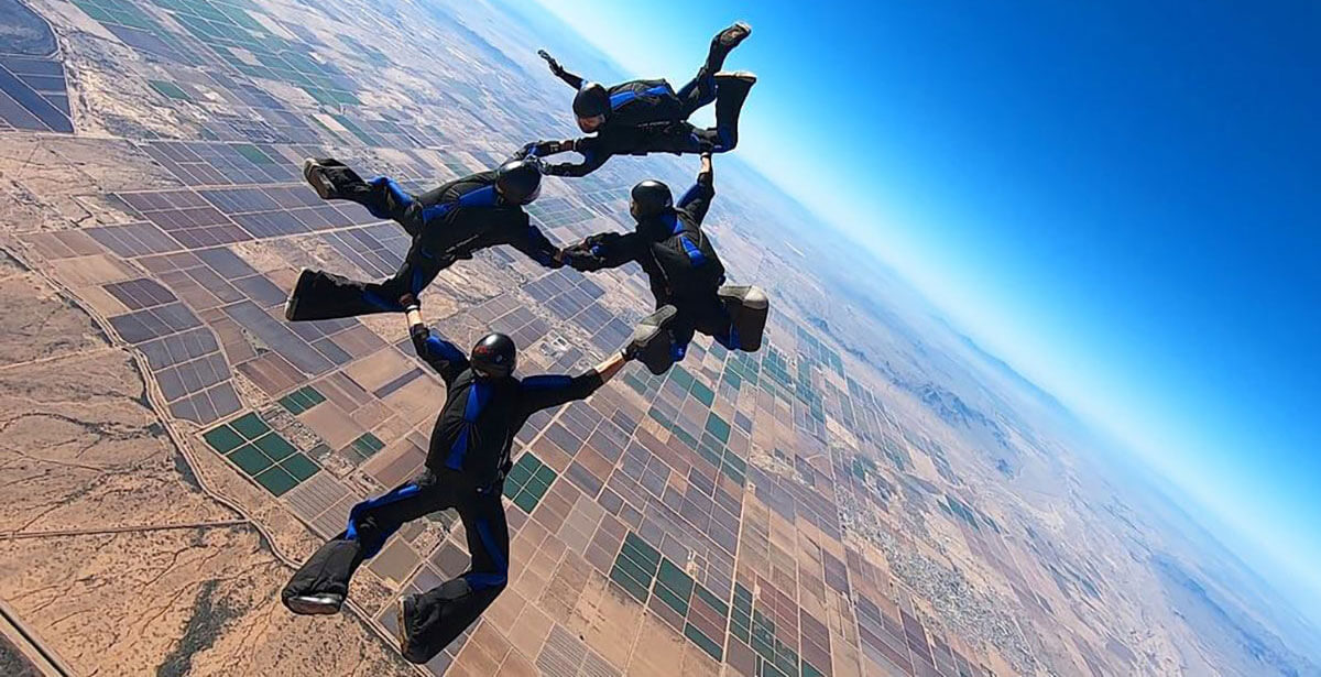 Wings of Blue members skydiving high above fields