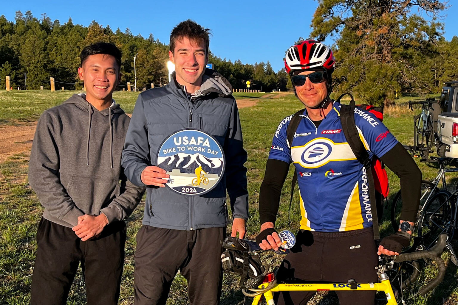 Cadet 2nd Class Emmanuel Lorenzo, left, Cadet 1st Class Sean Maison, middle, and U.S. Air Force Lt. Col. Ryan Carr pose for a photo before their Bike to Work commute.