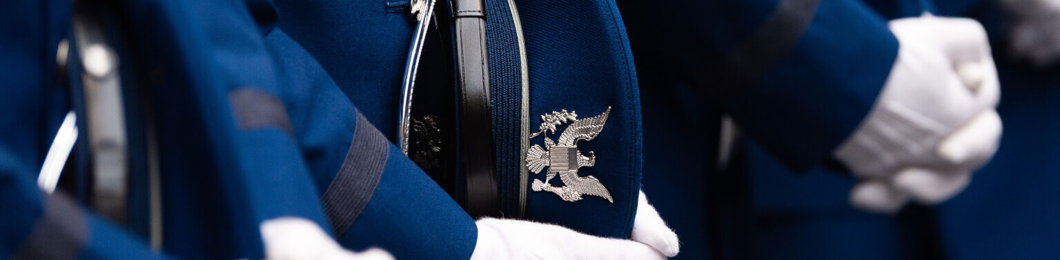 Cadets with white gloves holding their service caps.